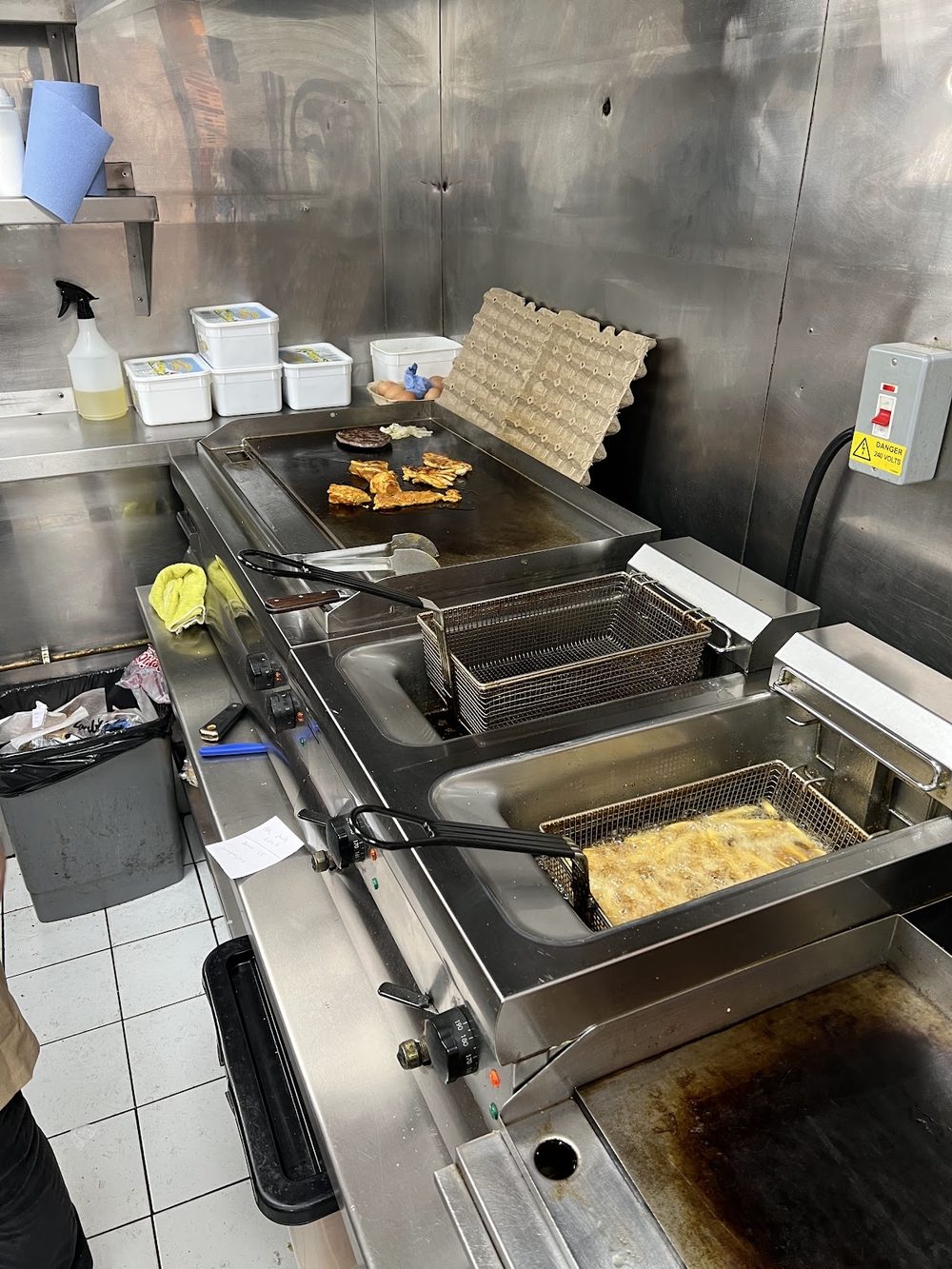 The stainless steel kitchen line with the hot plate and fryers going