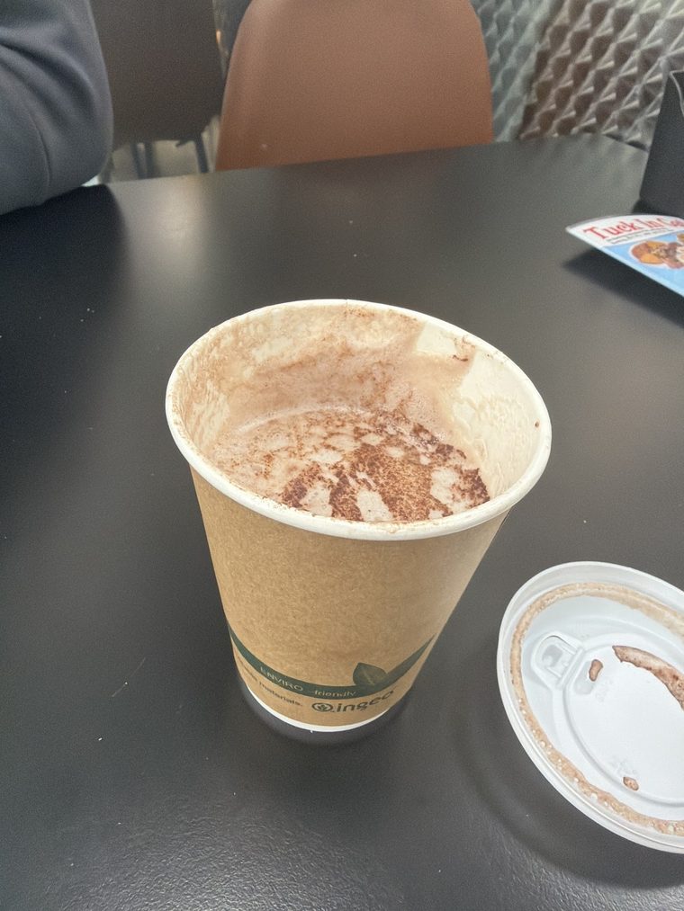 A takeaway cappuccino dusted with chocolate