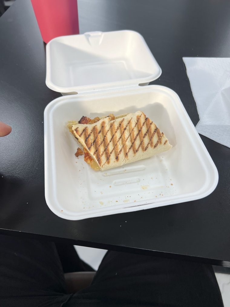 A toasted sandwich in a takeaway box